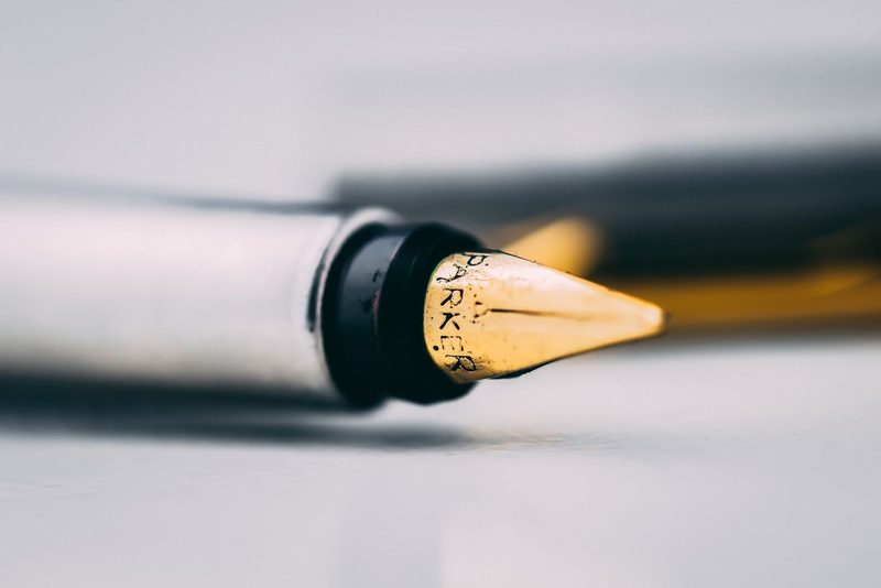 A fountain pen nib in close-up, in ink duotone.